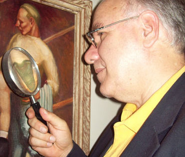 Art appraiser using magnifying glass to determine value.